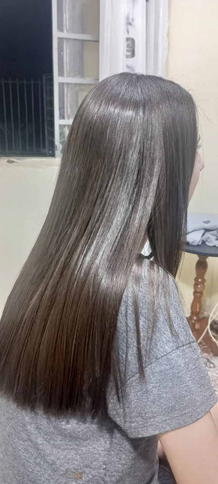 Cabelo feminino longo, liso e com brilho, visto de lado depois do tratamento